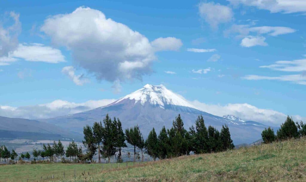 Snow-capped volcano rising up toward sky in Ecuador
