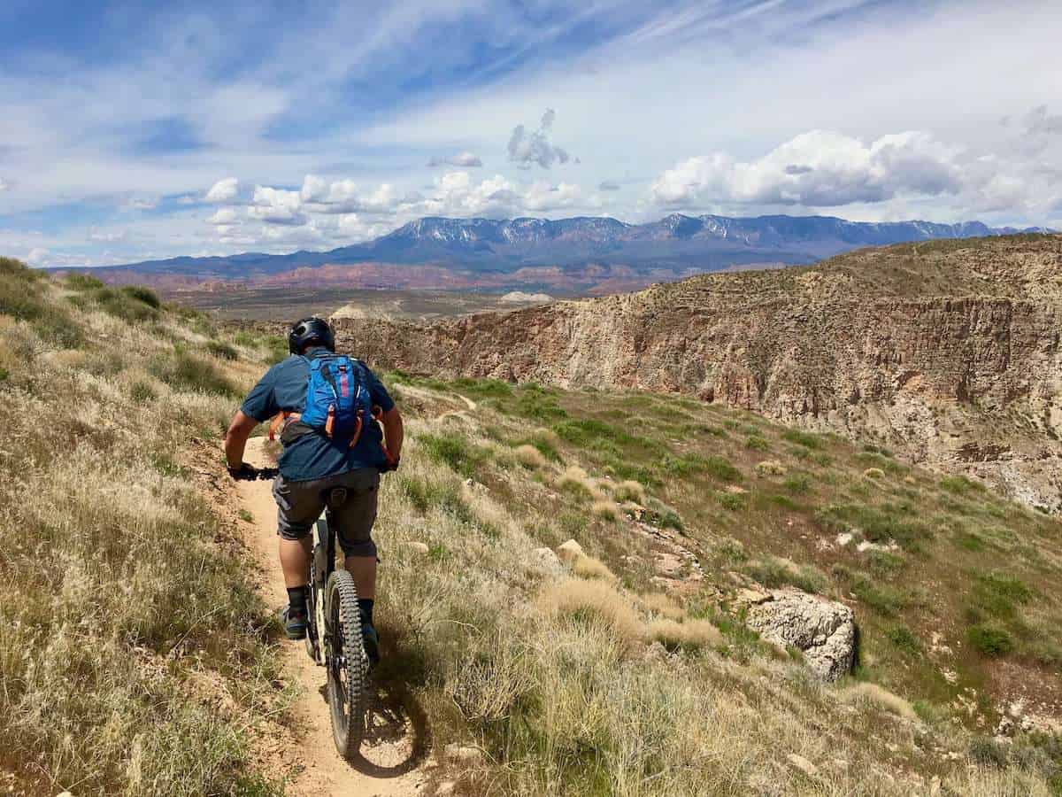 Mountain biker riding away from camera on scenic singletrack trail in Hurricane, Utah