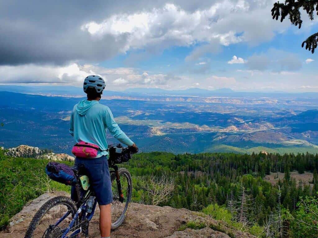 Bikepacker at view point overlooking Utah forest and red rock landsapes
