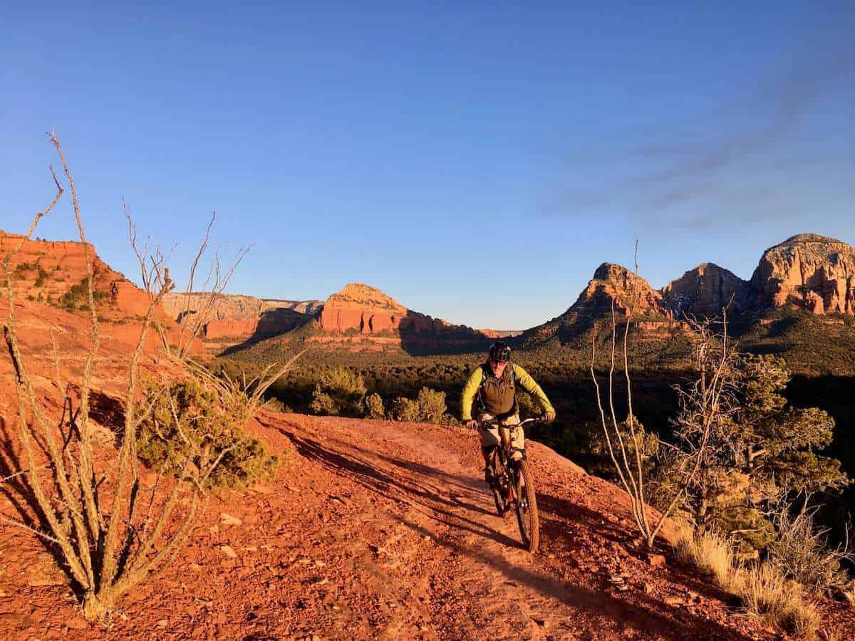 Mountain biker riding trail in Sedona with golden sunset glow