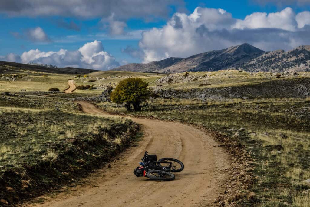 Bike laying in middle of remote dirt road on European Divide Bikepacking Route