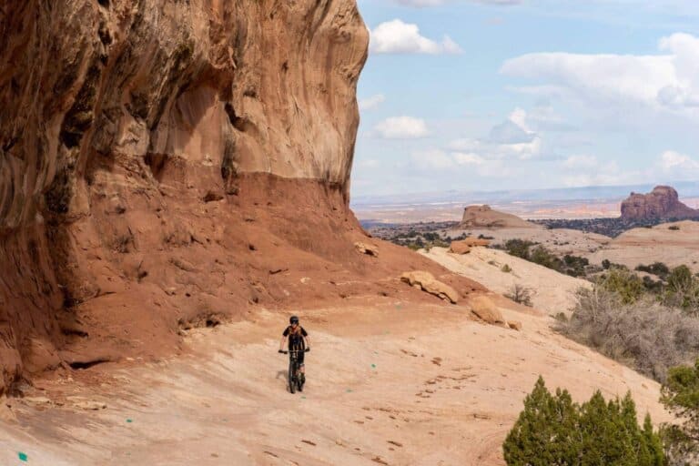 Mountain biker riding red slickrock slab in Moab, Utah