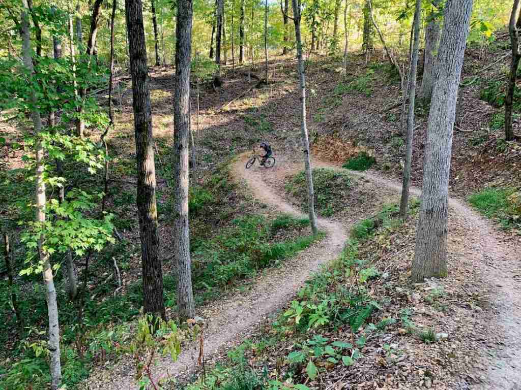 Mountain biker turning around switchback on forested trail