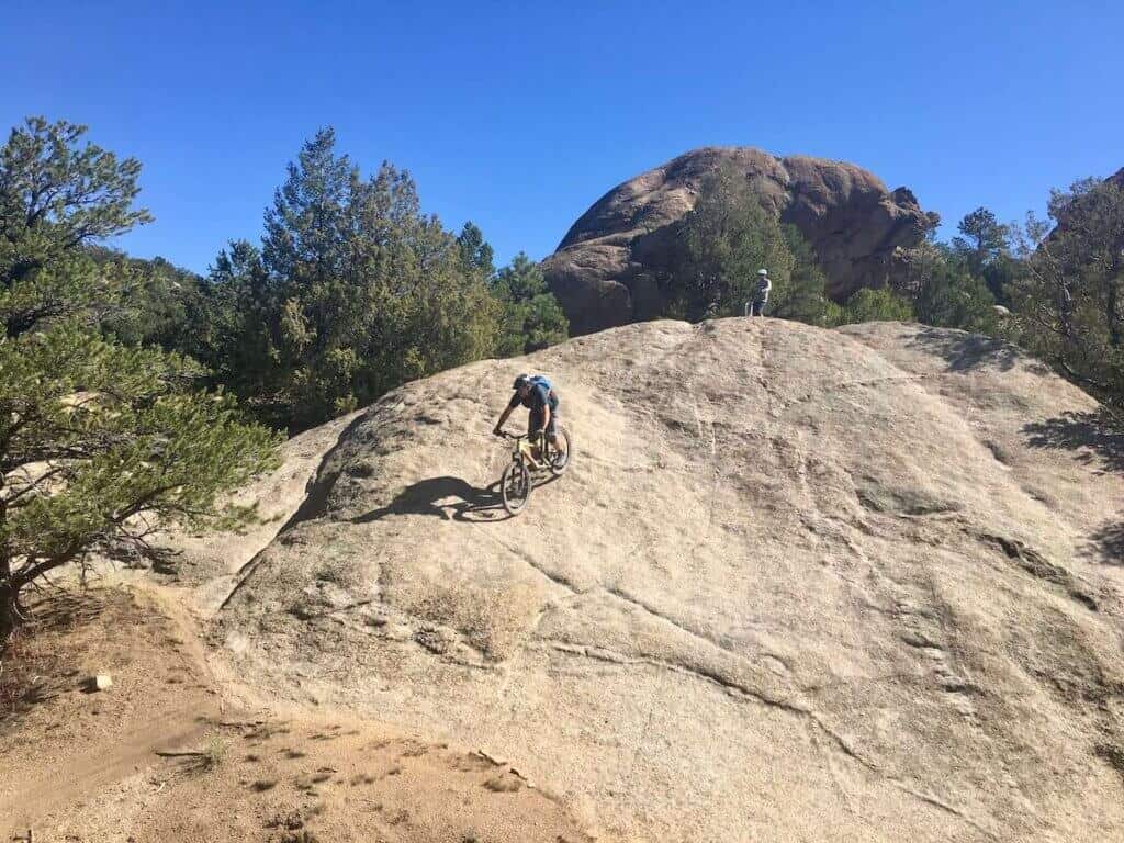 Mountain biker riding bike down huge, steep rock slab in Buena Vista, Colorado
