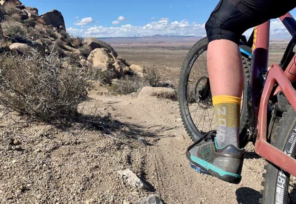 Close up photo of mountain bikers left foot wearing Five Ten mountain bike shoe on trail in California