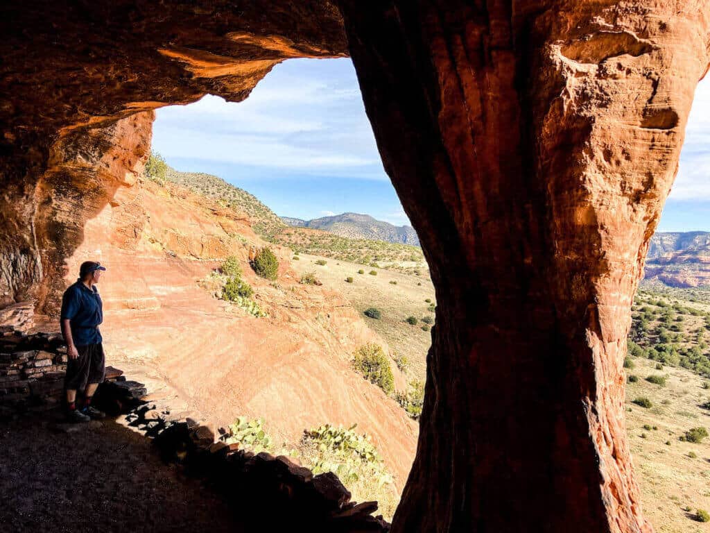 Man standing in archway of Robbers Roost in Sedona Arizona
