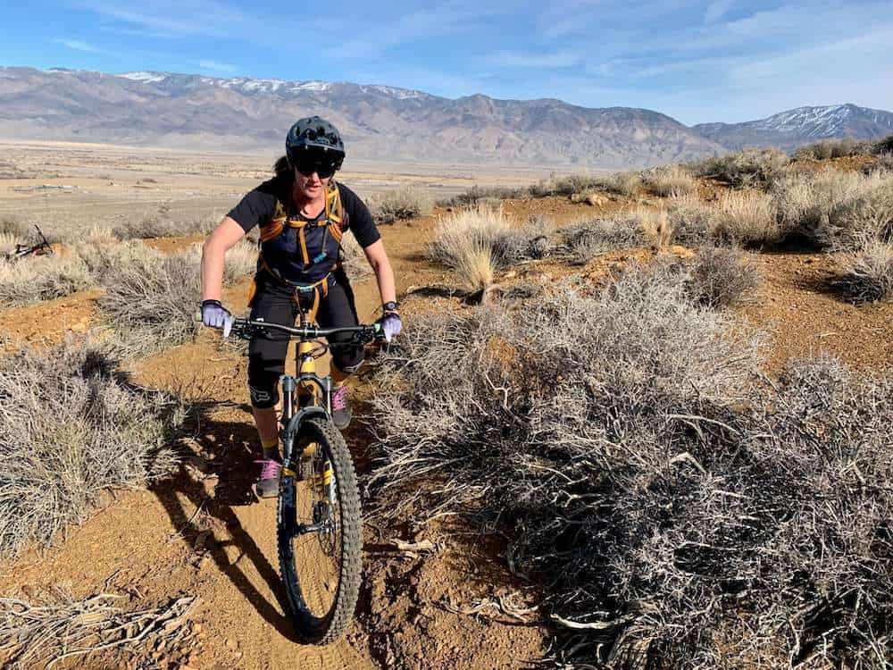 Becky on mountain bike riding singletrack trail in Bishop, California