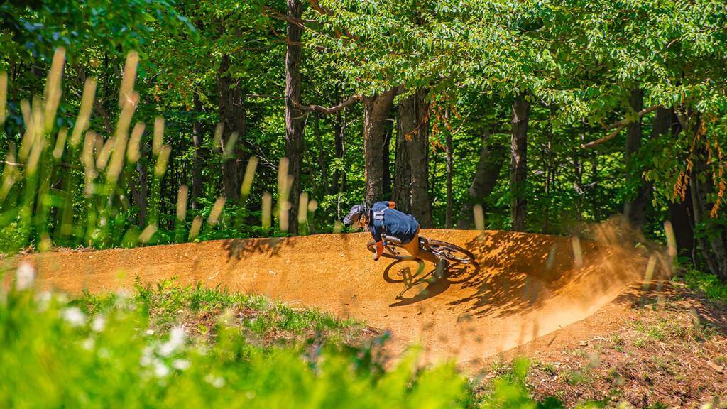 Mountain biker on bermed turn at Stratton Mountain Bike Park in Vermont