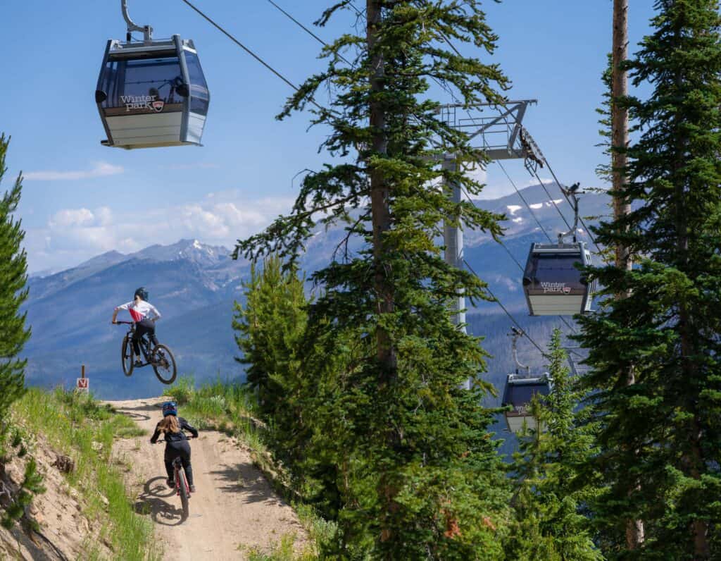 Mountain bikers on trail under gondola at Trestle Bike Park in Colorado