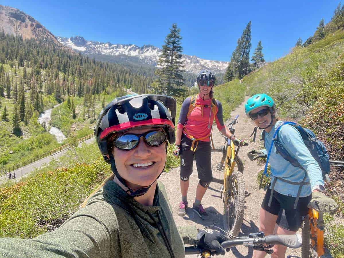 Three female mountain bikers posing for selfie on trail in Mammoth Lakes California