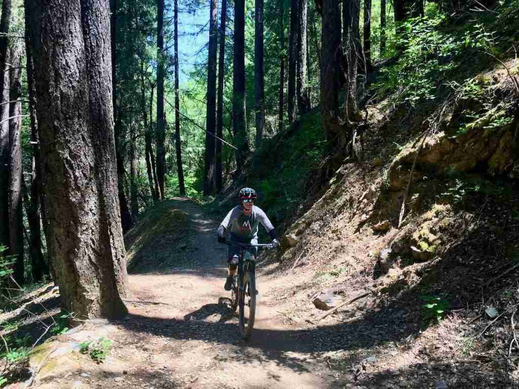 Woman riding mountain bike on trail in California
