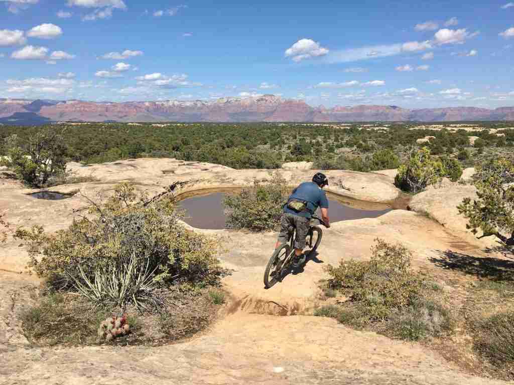 Mountain biker riding bike on slickrock trail on Gooseberry Mesa in Utah