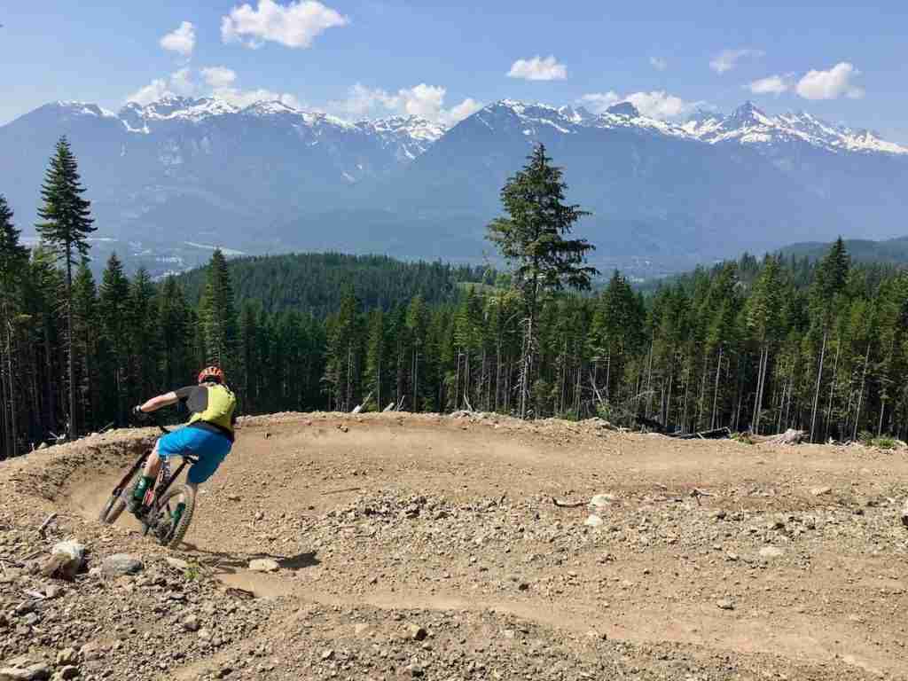 Man riding mountain bike down bermed flow trail in Squamish, British Columbia