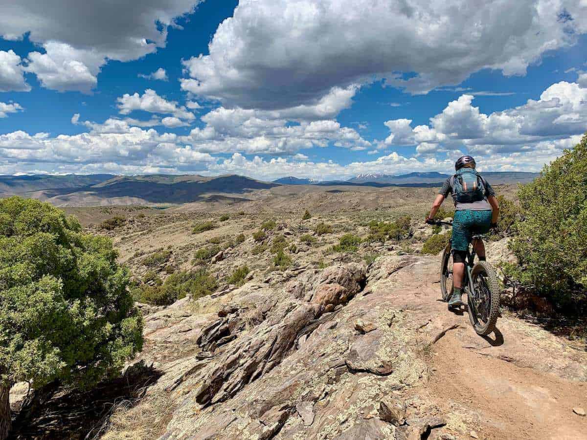 Becky pedaling away from camera on mountain bike trail in Hartman Rocks Colorado