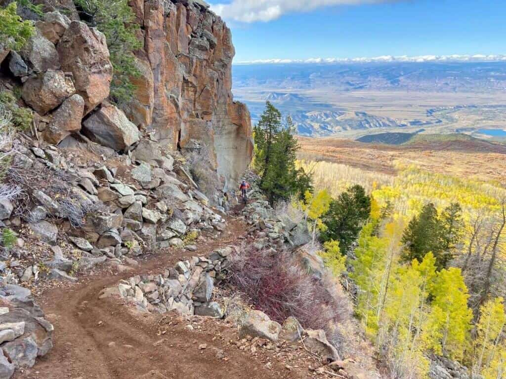 Section of Palisade Plunge mountain bike trail in Colorado with epic views over valley and changing aspen leaves