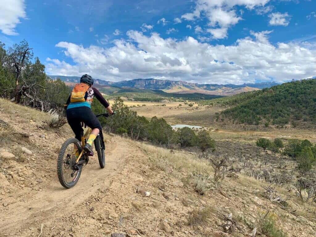 Female mountain biker riding bike on singletrack trail in Ridgway Colorado