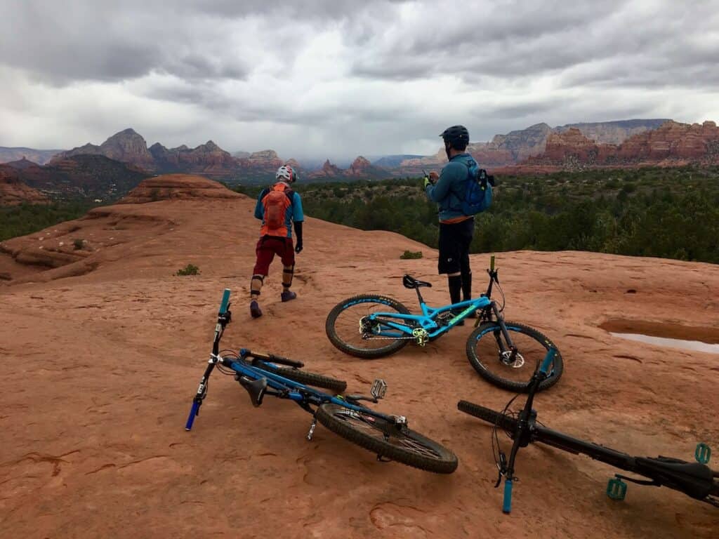 Mountain bikers on large red rock slab in Sedona called Submarine Rock
