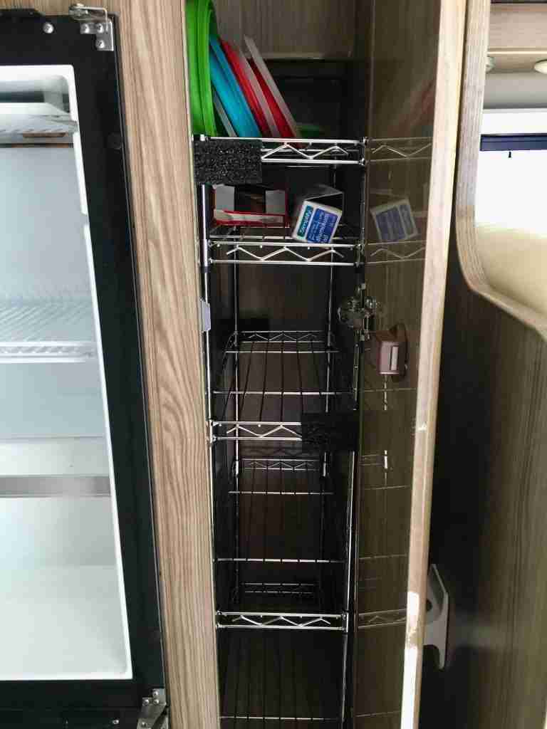 DIY metal pantry shelves inside cupboard of camper van