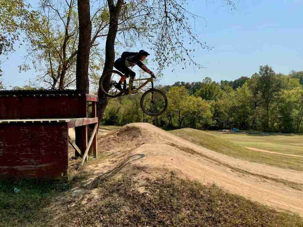 Becky riding off bike wooden drop on mountain bike