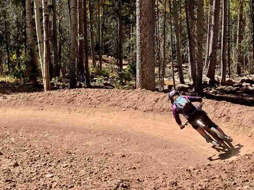 Mountain biker riding bermed turn at Angel Fire Bike Park in New Mexico