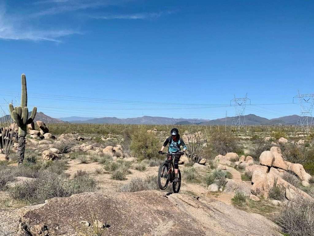 Becky Riding mountain bike up rock slab at Brown's Ranch in Phoenix, Arizona