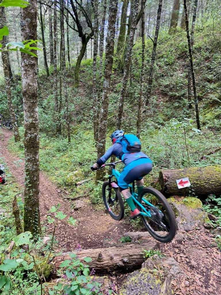 Mountain biker riding of natural drop on singletrack trail in the woods of Oaxaca, Mexico
