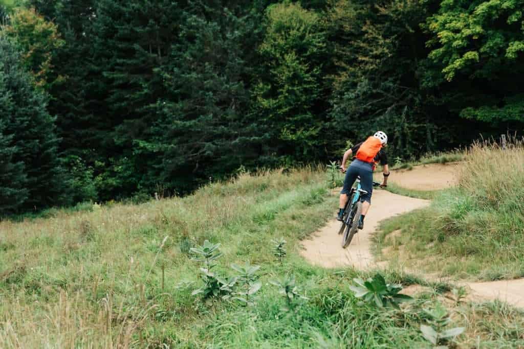 Female mountain biker riding bike down flowy singletrack track