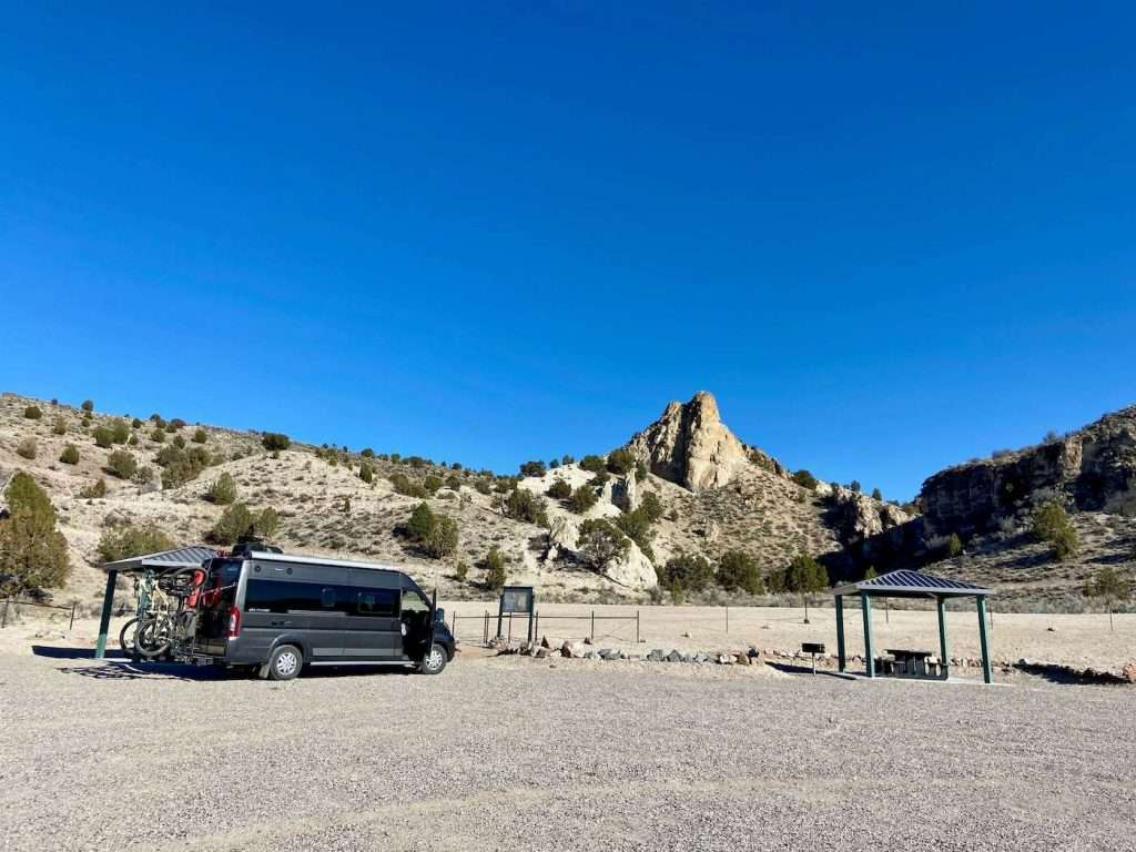 Van with two mountain bikes on the back parked at campsite in Nevada