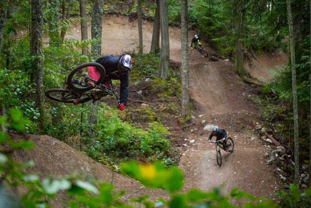Mountain bikers hitting large dirt jumps at Coast Gravity Bike Park in British Columbia
