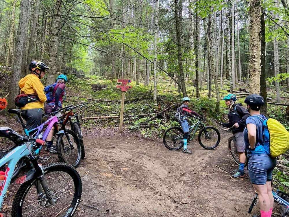 Group of women mountain bikers stopped on a trail during a skills clinic at the Kingdom Trails in Vermont