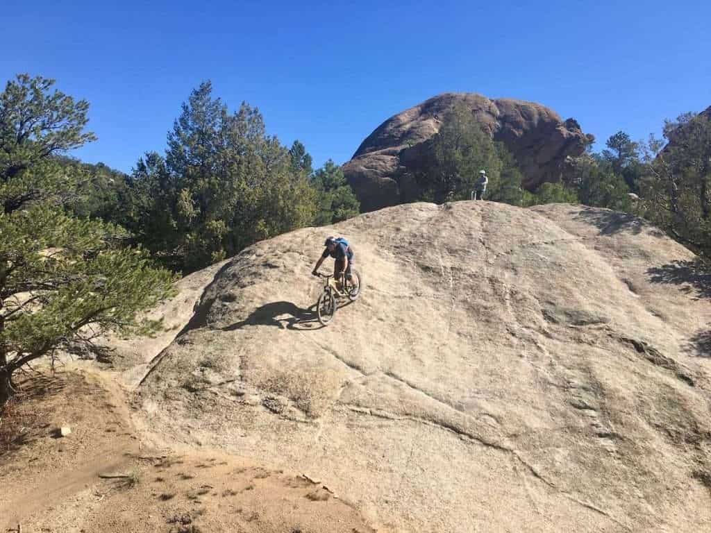 Mountain biker riding down large rock slab in Colorado