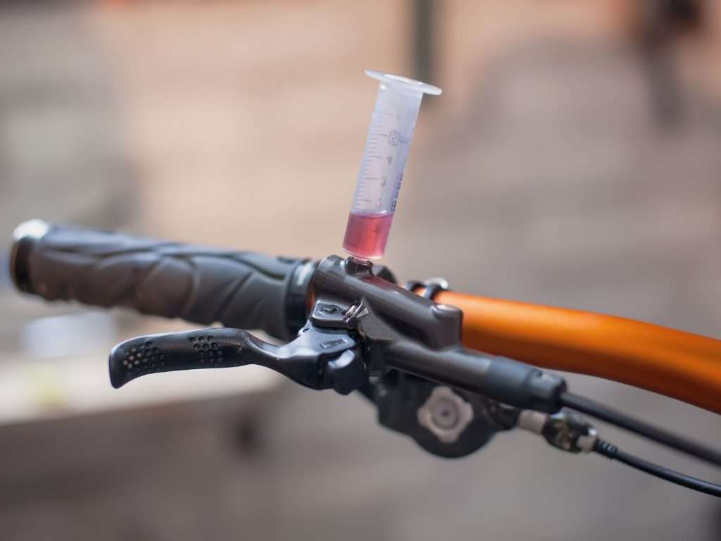 Mountain bike handlebar with brake bleed kit inserted into brake lever