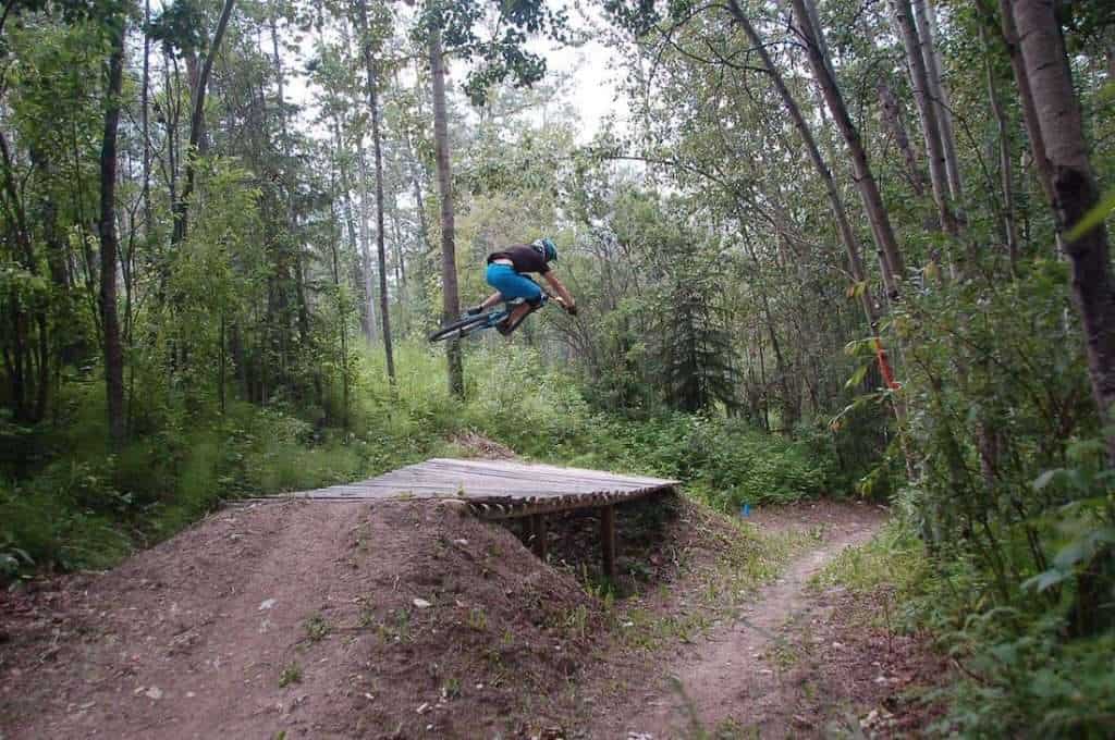 Mountain biker in the air over a wooden tabletop jump