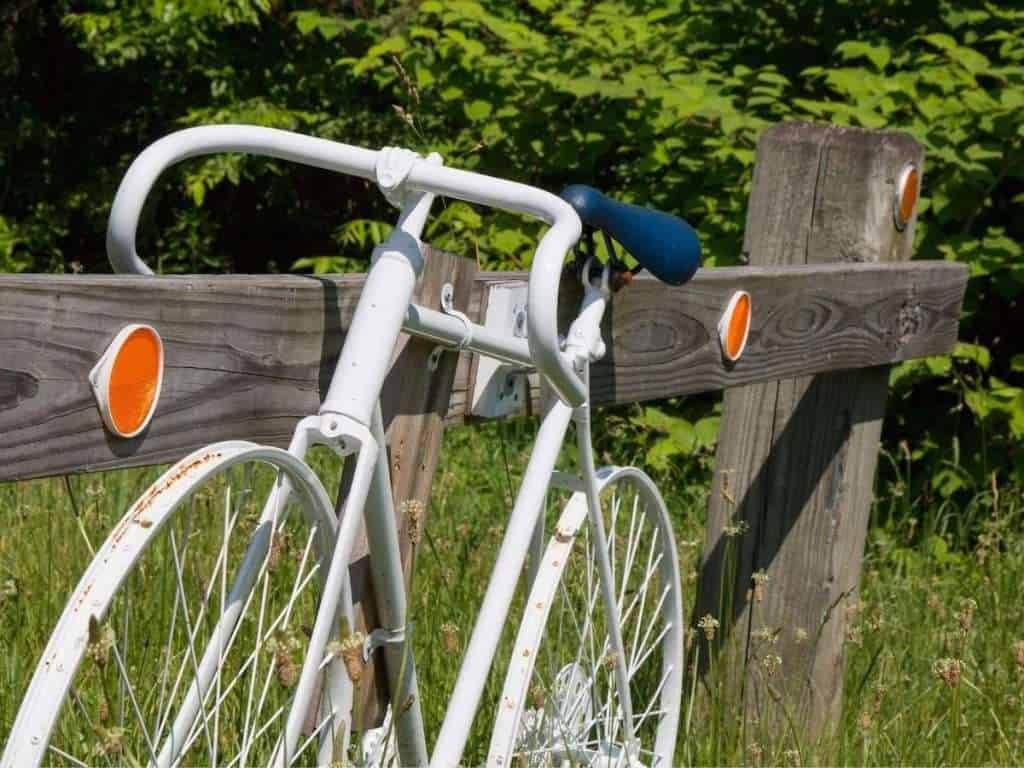 White ghost bike secured to fence signifying the death of a cyclist