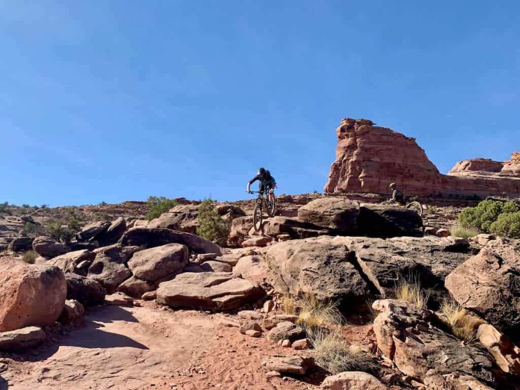Mountain biker riding down rock garden on slickrock trail in Moab, Utah