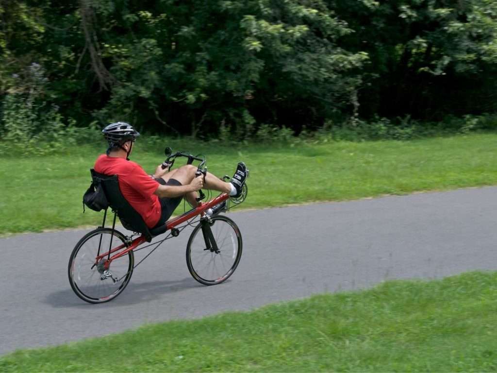 Man riding a recumbent bicycle on bike path