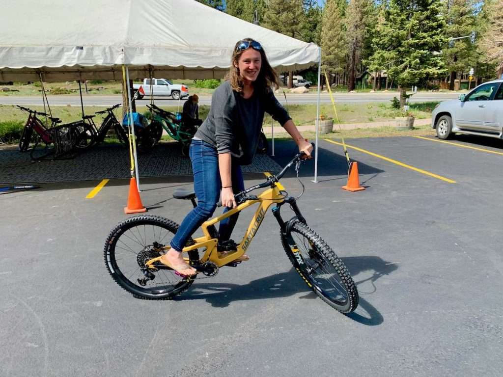 Becky riding new Santa Cruz Bronson in paved parking lot