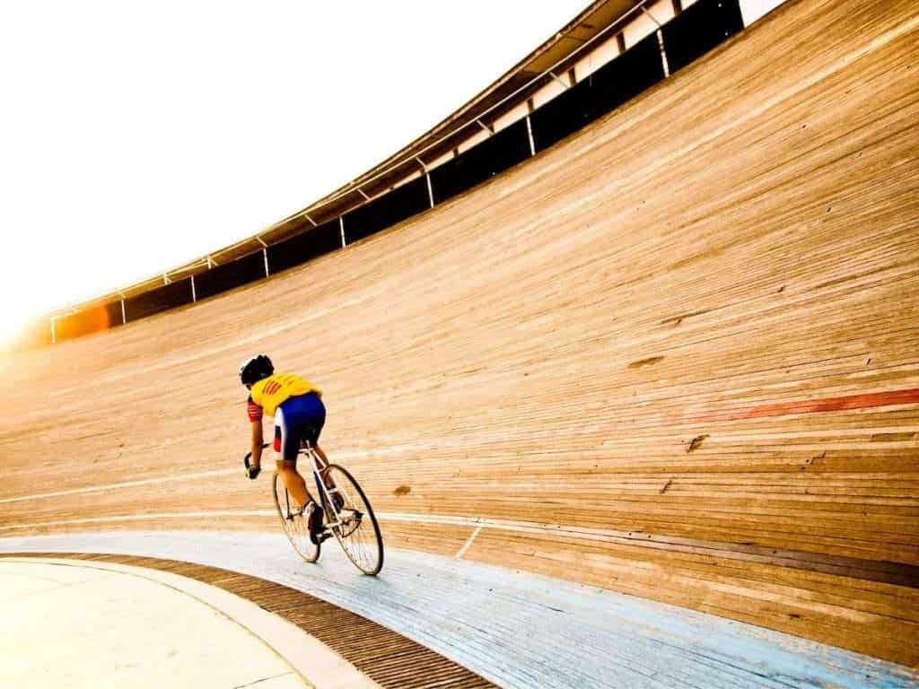 Cyclist riding around velodrome track
