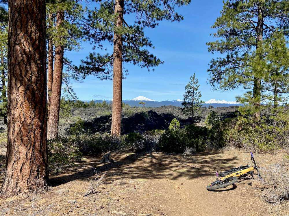 Mountain bike on trail in Bend, Oregon with snow capped volcano in far distance