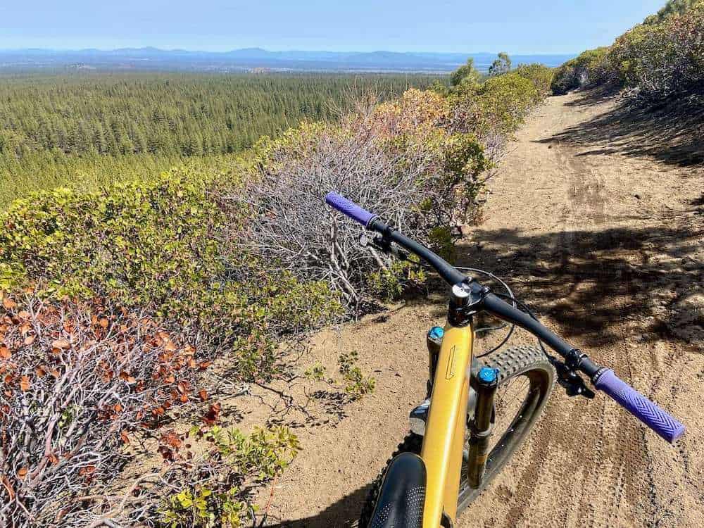 Mountain bike on singletrack trail with scenic views out over forest and mountains near Bend Oregon