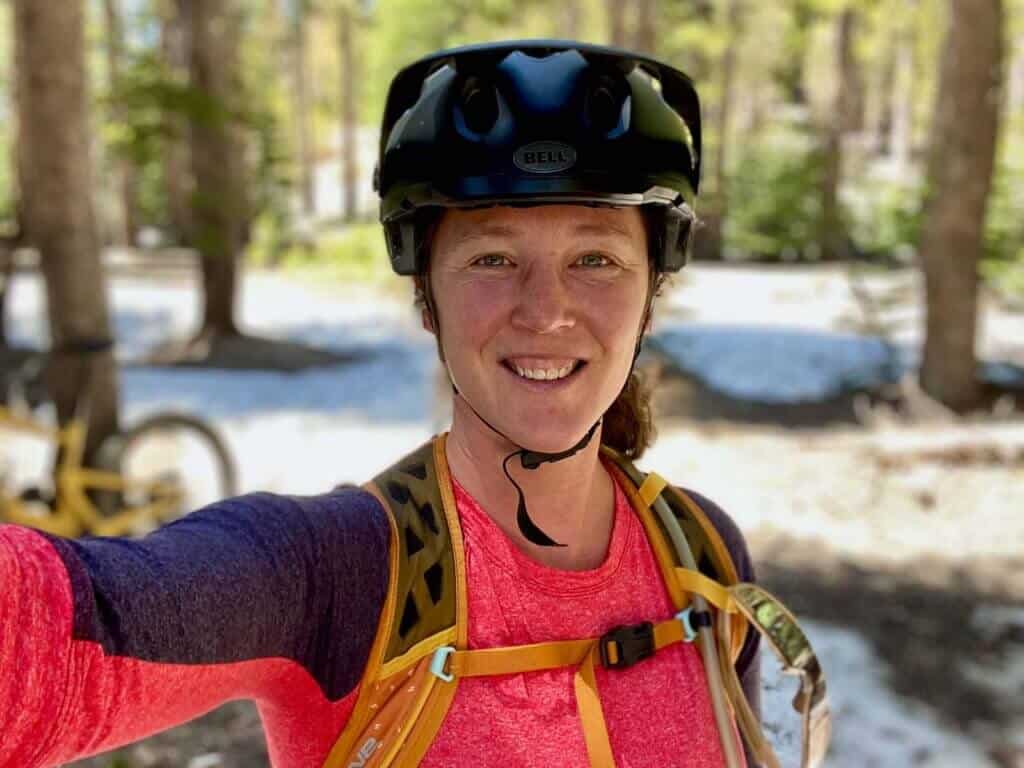 Head shot of Becky, founder of the Two Wheeled Wanderer bike blog, wearing a mountain bike helmet and bike jersey