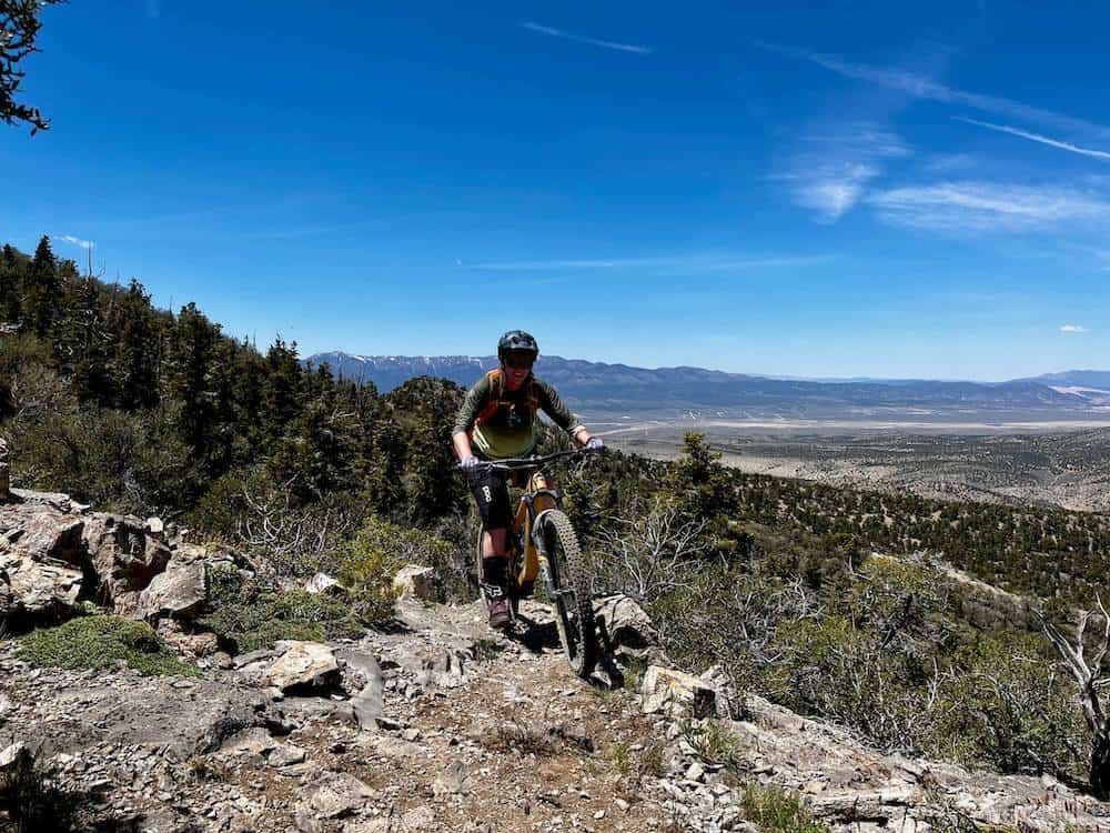 Becky riding up rocky section of trail on mountain bike in Ely Nevada