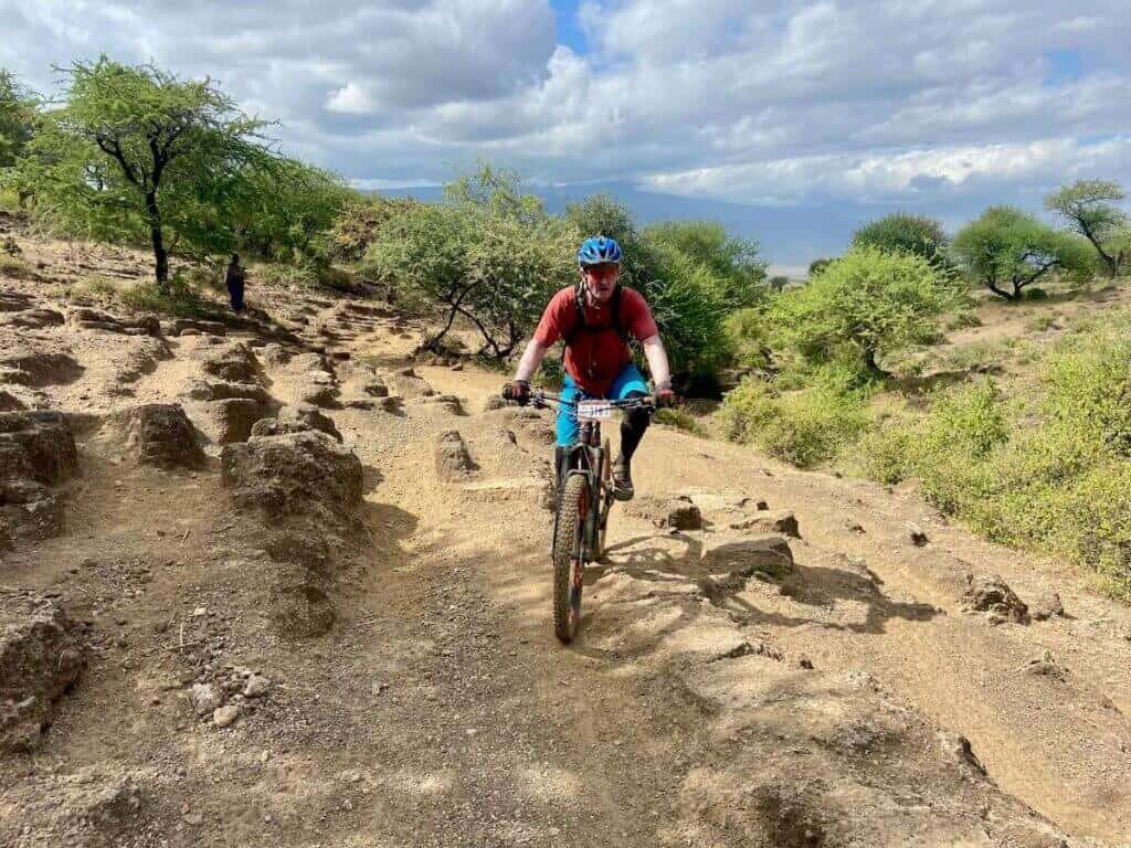 Mountain biker riding bike through unique rock formations on the the K2N mountain bike course in Tanzania