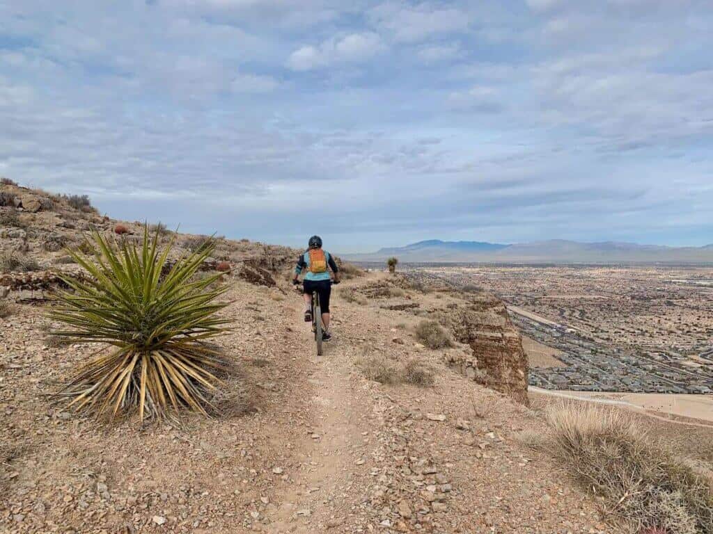 Mountain biker riding on singletrack trail on cliff edge above Las Vegas, Nevada