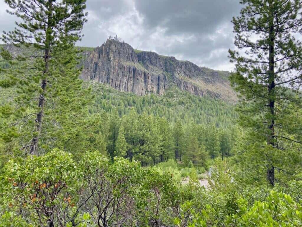 Tall rocky cliff behind river outside of Bend, Oregon
