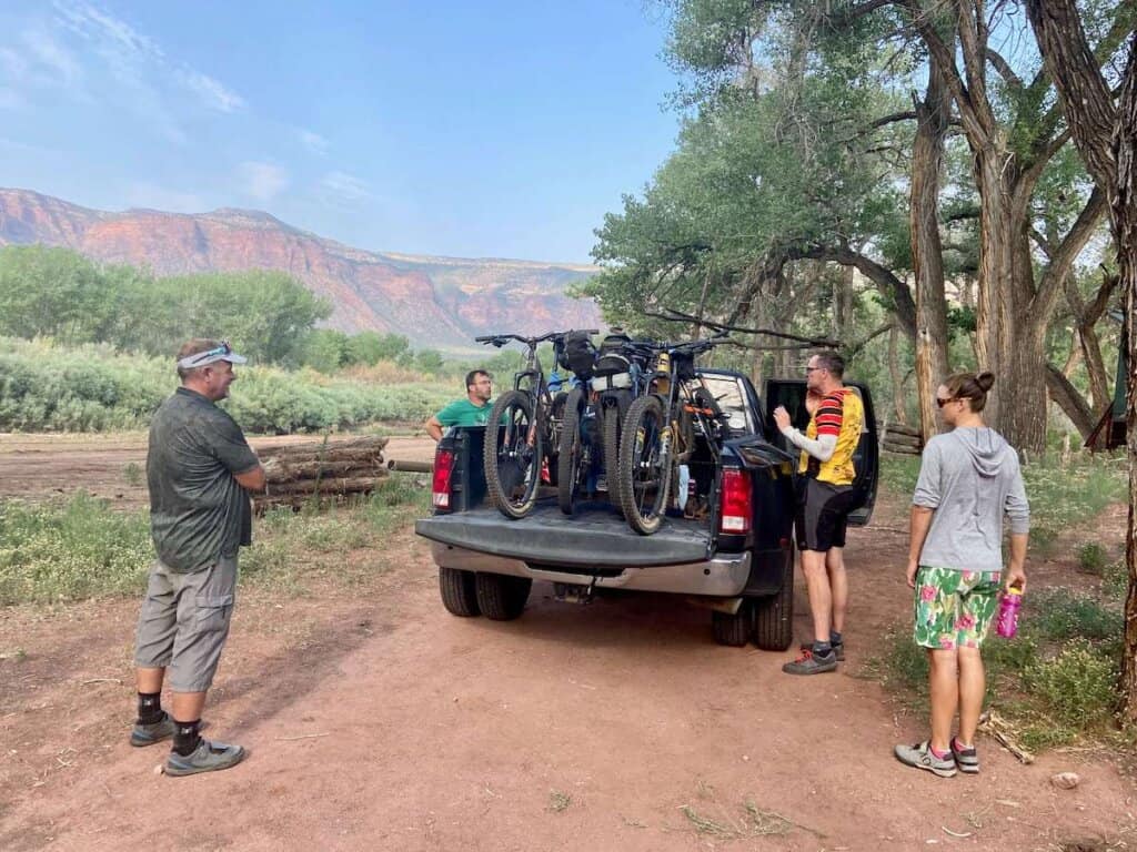 Cyclists loading mountain bikes in the back of pickup truck in Utah