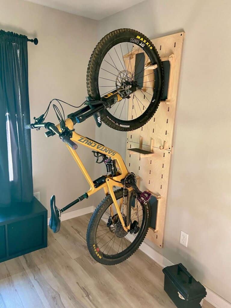 Mountain bike hanging on wooden vertical indoor bike rack inside apartment