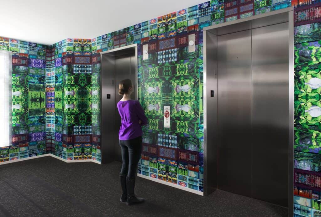 person waiting for elevator in colorful lobby