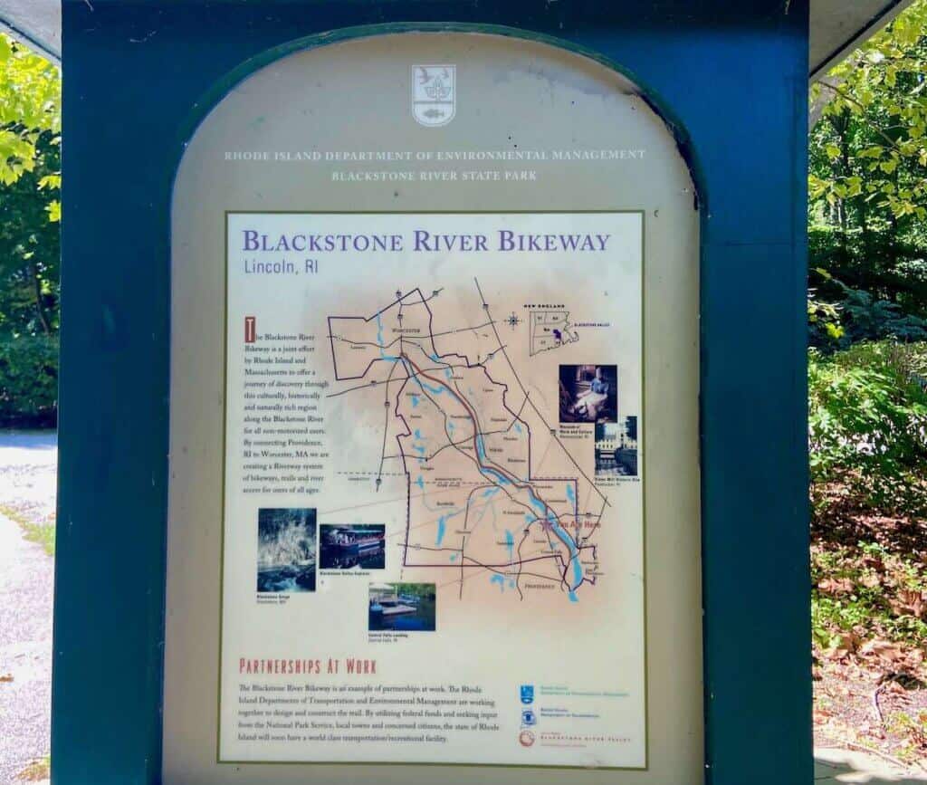 Historical marker of the Blackstone River Bikeway with map and photos