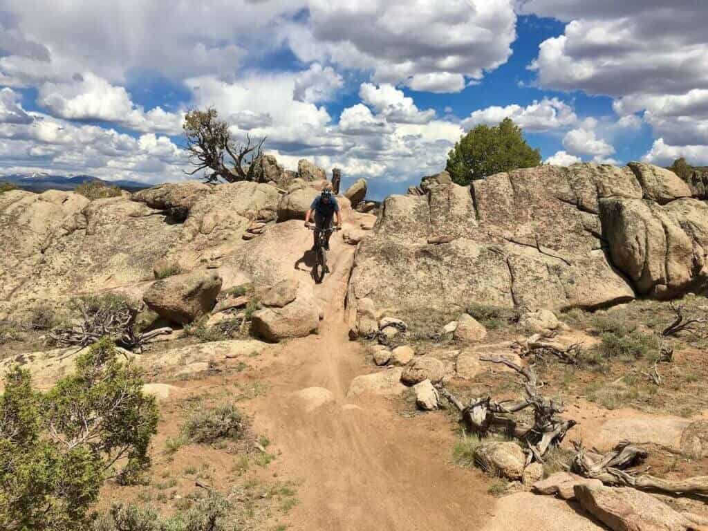 Mountain biker riding down steep rock chute at Hartman Rocks in Colorado